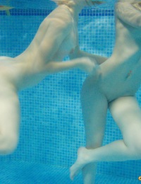 Two horny lesbian teenagers swimming together in a pool
